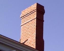 A brick chimney is replaced. The reproduction is a perfect match of the original design.