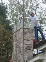 A stone chimney cap is installed.